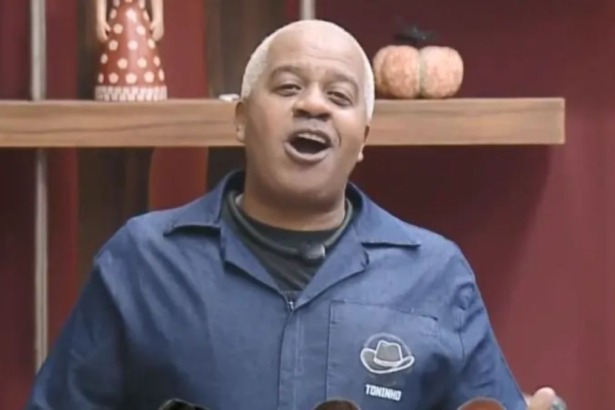 Toninho com a boca aberta pedindo votos no canto da sala de A Fazenda 17