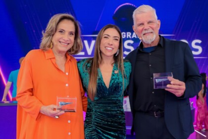 Apresentadora Patricia Abravanel com os atores Totia Meireles e Raul Gazolla, todos segurando troféus no palco do Programa Silvio Santos