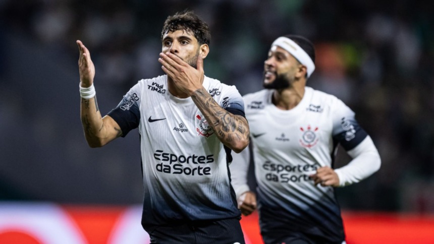 Yuri Alberto atacante do Corinthians comemorando gol com um beijo na camisa branca, com o Memphis correndo no fundo após lance na final do Paulistão 2025