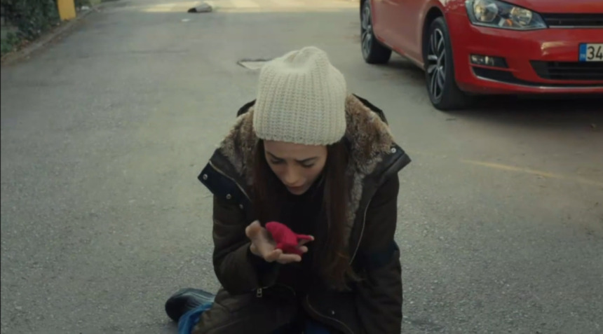 Zeynep entra em desespero e se joga no chão de uma rua chorando desesperada ao ver Meleke/Turna ser sequestrada em cena da novela Mãe