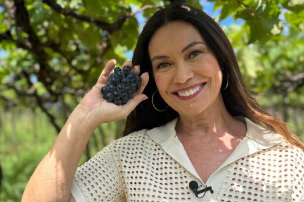 Jornalista Beatriz Castro com um cacho de uva nas mãos em trecho do Globo Repórter