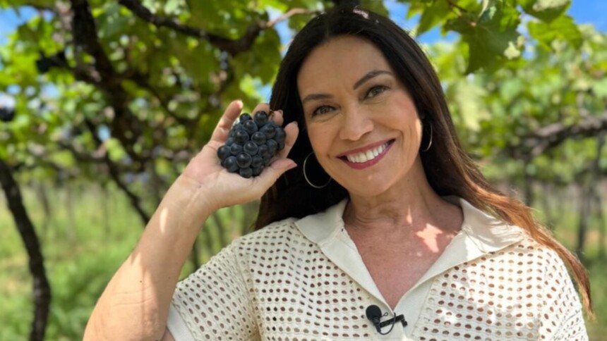Jornalista Beatriz Castro com um cacho de uva nas mãos em trecho do Globo Repórter