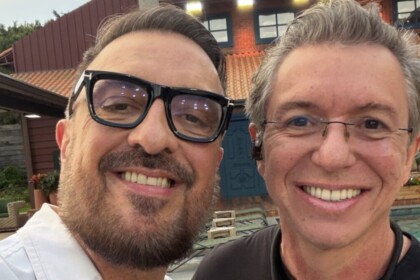 Carelli e Boninho sorridentes e abraçados na área externa da sede de A Fazenda