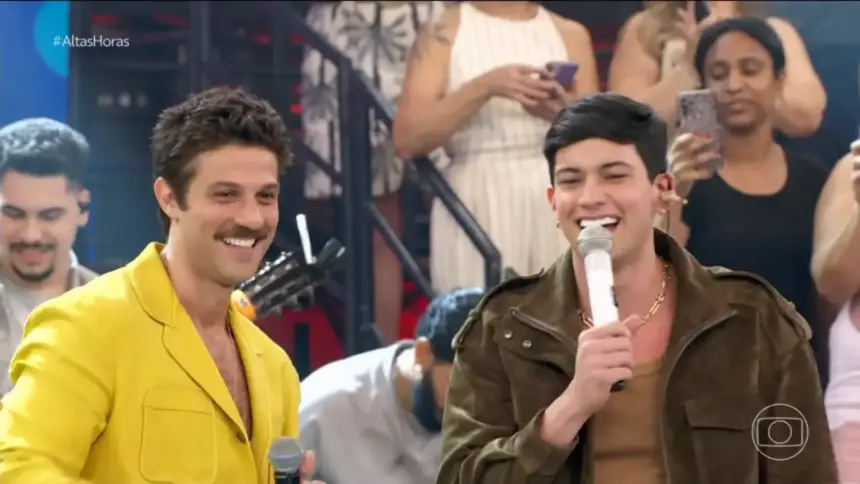 Chay Suede e Léo Foguete sorrindo no palco do Altas Horas após imitarem João Gomes