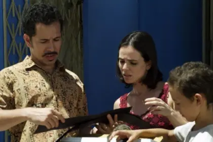 Casal observa um álbum de fotos em cena do filme Cine Holliúdy