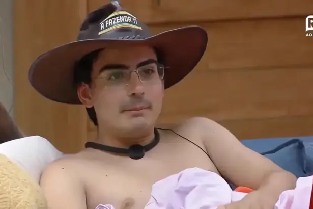 Dudu Camargo com chapéu de fazendeiro na cabeça e sem camisa na sala de A Fazenda