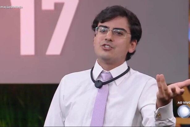 Dudu Camargo de gravata rosa e blusa branca no cenário da Formação da Roça de A Fazenda 17