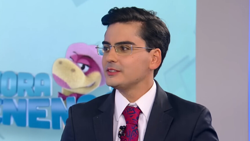 Dudu Camargo, de terno e gravata, em trecho de participação no cenário do Balanço Geral na RECORD