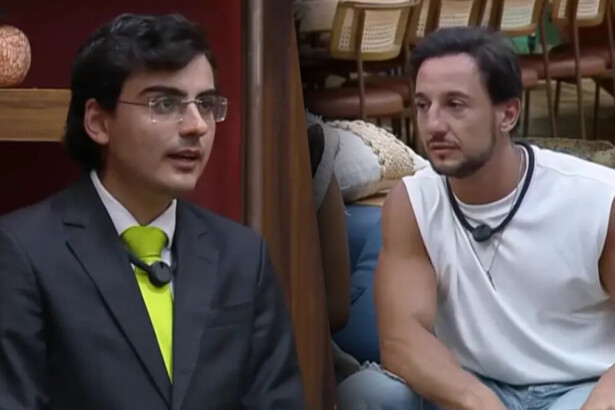 Dudu Camargo de terno e gravata amarela no canto da sala de A Fazenda 17 dividindo tela com Mesquita de camiseta regata branca, sentado no sofá da sala do reality
