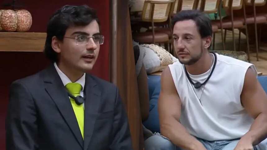 Dudu Camargo de terno e gravata amarela no canto da sala de A Fazenda 17 dividindo tela com Mesquita de camiseta regata branca, sentado no sofá da sala do reality