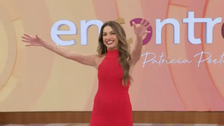 Patricia Poeta abre os braços em frente ao telão com o logo do programa Encontro