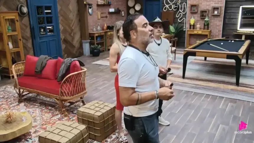 Fabiano com dardo na mão para atirar na foto de Duda dentro do Rancho do Fazendeiro em A Fazenda 17