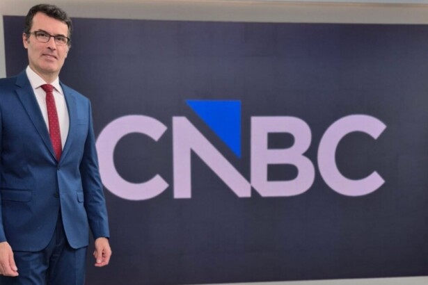 Fabio Turci em frente ao telão no cenário do CNBC