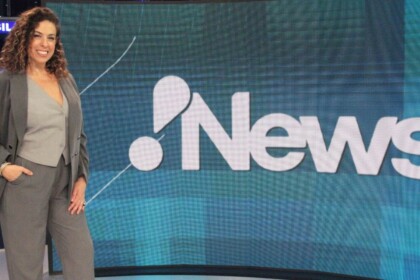 Fabíola Cidral posando em frente ao telão no estúdio do RedeTV! News