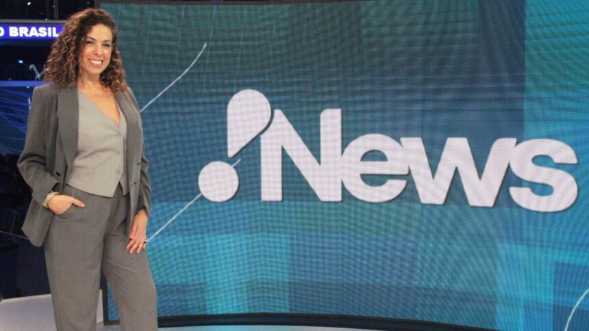 Fabíola Cidral posando em frente ao telão no estúdio do RedeTV! News