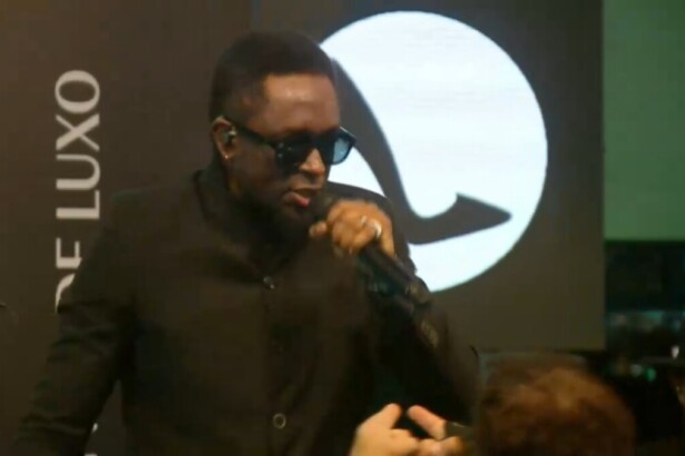 Vocalista do Serial Funkers canta na festa de A Fazenda 17. Atrás dele um logo do patrocinador Sapatinho de Luxo