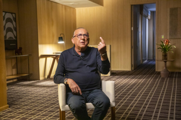 Galvão Bueno sentado em uma cadeira bege