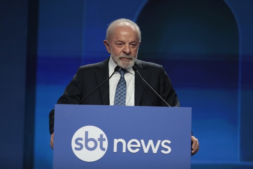 Lula discursa no púlpito com o logo do SBT News