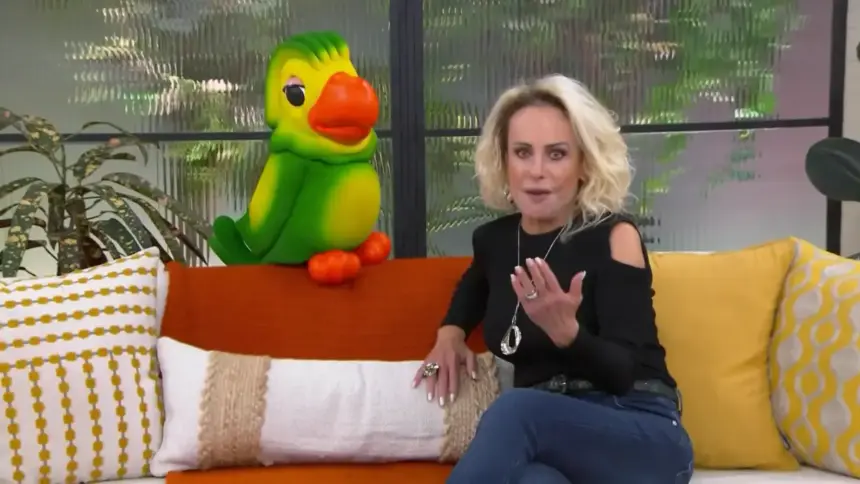 Ana Maria Braga sentada no sofá do Mais Você ao lado do Louro Mané