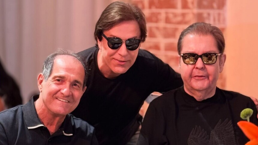 Muricy Ramalho sorrindo ao lado de Tom Cavalcante e Faustão, ambos de óculos escuros, em close-up de encontro