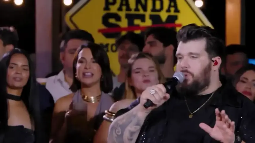 Cantor Panda se apresentando em show, ao fundo uma plateia
