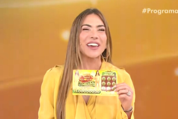 Patricia Abravanel sorri segurando uma Tele Sena de Natal em trecho do quinto sorteio