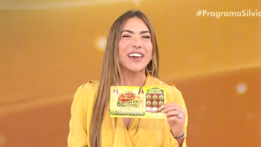 Patricia Abravanel sorri segurando uma Tele Sena de Natal em trecho do quinto sorteio