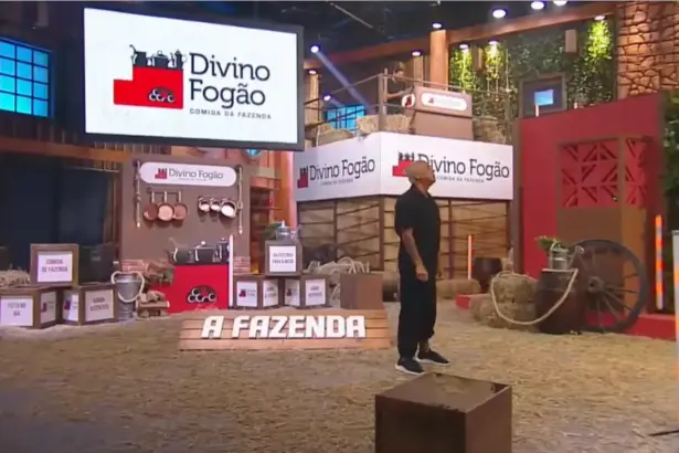 Telões com o logo do Divino Fogão no cenário da última Prova de A Fazenda 17. Walério em pé no centro do cenário