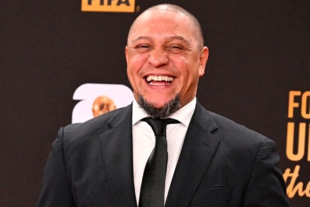 Lateral Roberto Carlos de terno e gravata, sorridente em foto posada em um evento da FIFA