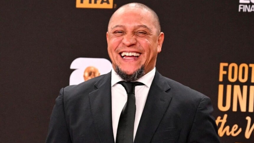 Lateral Roberto Carlos de terno e gravata, sorridente em foto posada em um evento da FIFA