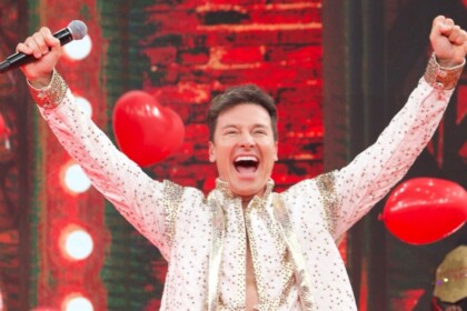 Rodrigo Faro celebrando de braços abertos no palco do Domingão
