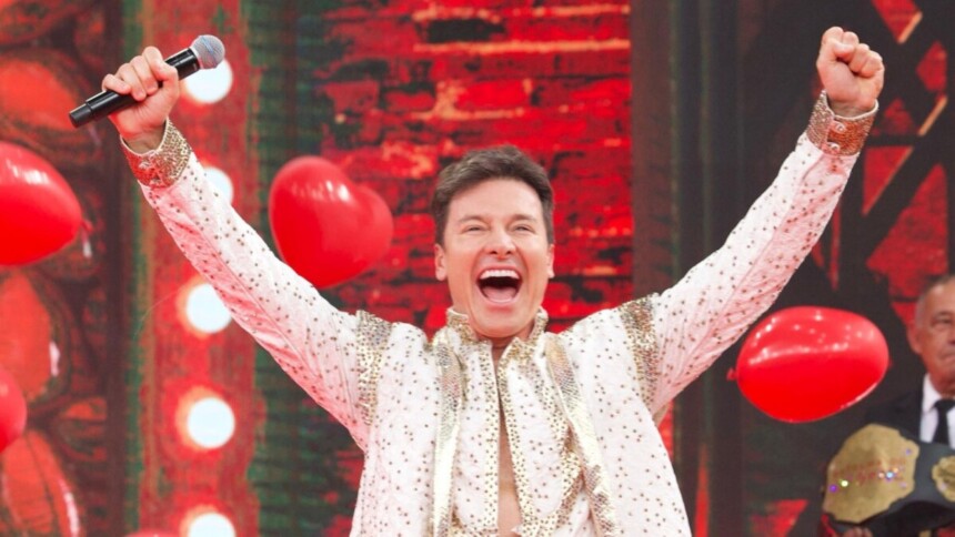 Rodrigo Faro celebrando de braços abertos no palco do Domingão