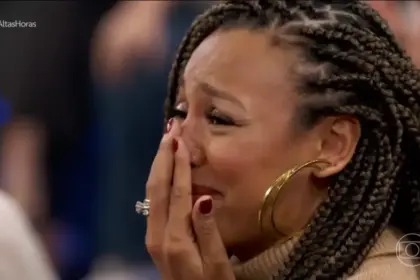 Sheron Menezzes chorando com a mão na boca no palco do Altas Horas ao ver o cantor Djavan