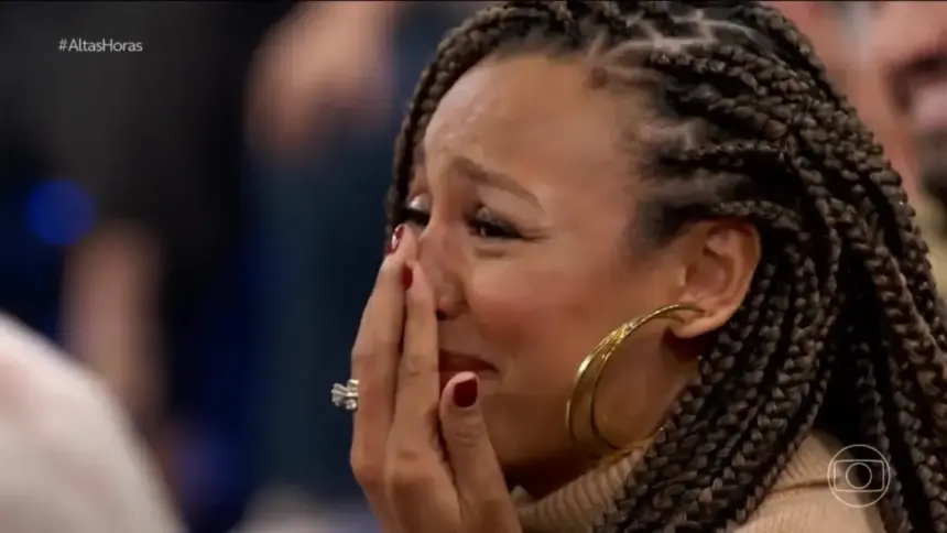 Sheron Menezzes chorando com a mão na boca no palco do Altas Horas ao ver o cantor Djavan