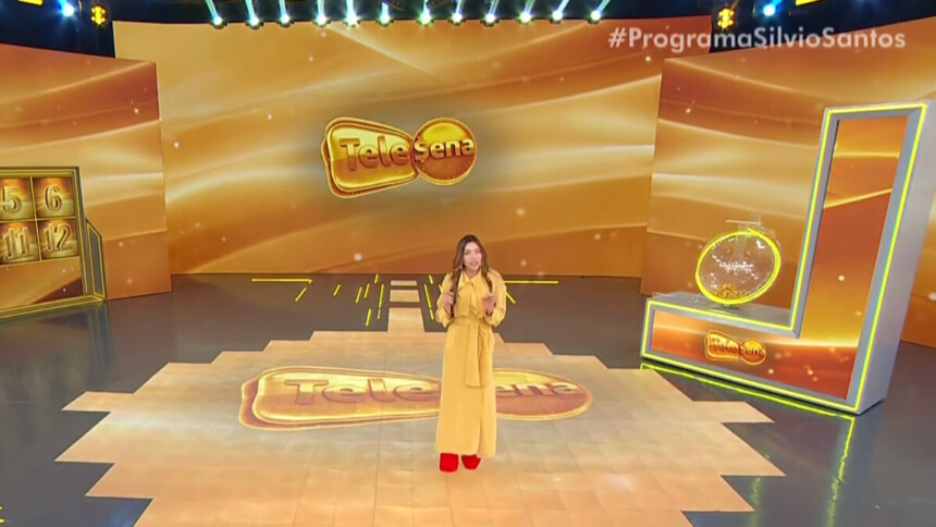 Patricia Abravanel no centro do palco do 3º sorteio da Tele sena de Natal com o cenário todo dourado