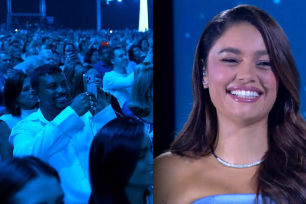 Xamã segura um celular, sorrir, e filma Sophie Carlotte no palco do Especial Roberto Carlos