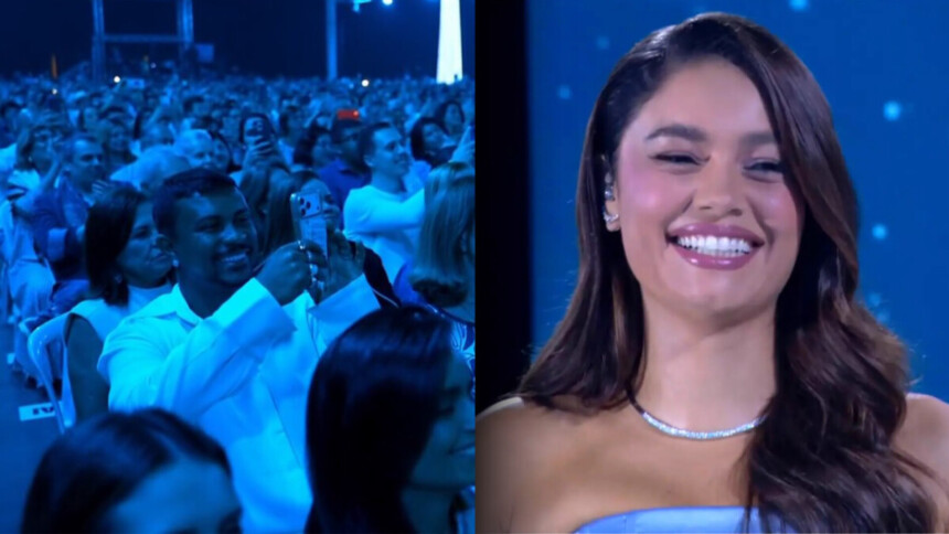 Xamã segura um celular, sorrir, e filma Sophie Carlotte no palco do Especial Roberto Carlos