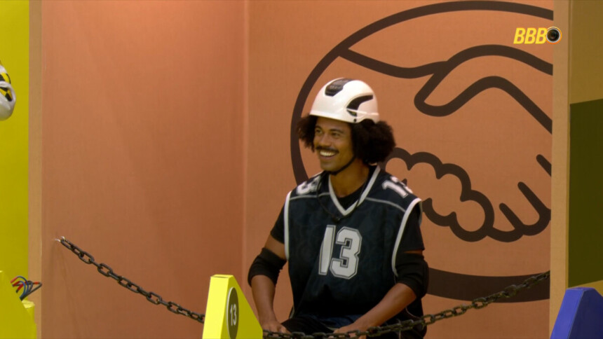 Breno sentado no descanso e sorrindo na Prova do Líder do BBB 26