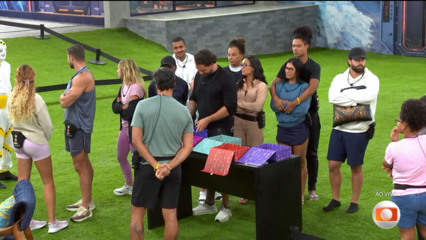 Participantes em pé na frente das Caixas-Surpresa no gramado do BBB 26