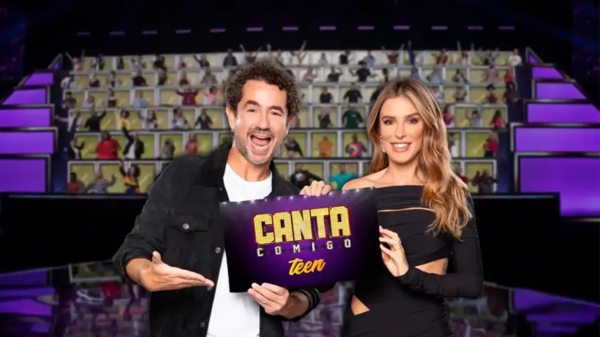 Felipe Andreoli e Rafa Brites seguram ficha do Canta Comigo Teen no palco do reality da RECORD em frente ao paredão dos jurados