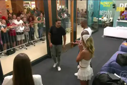 Participantes da Casa de Vidro em pé olhando para o público do lado de fora do shopping