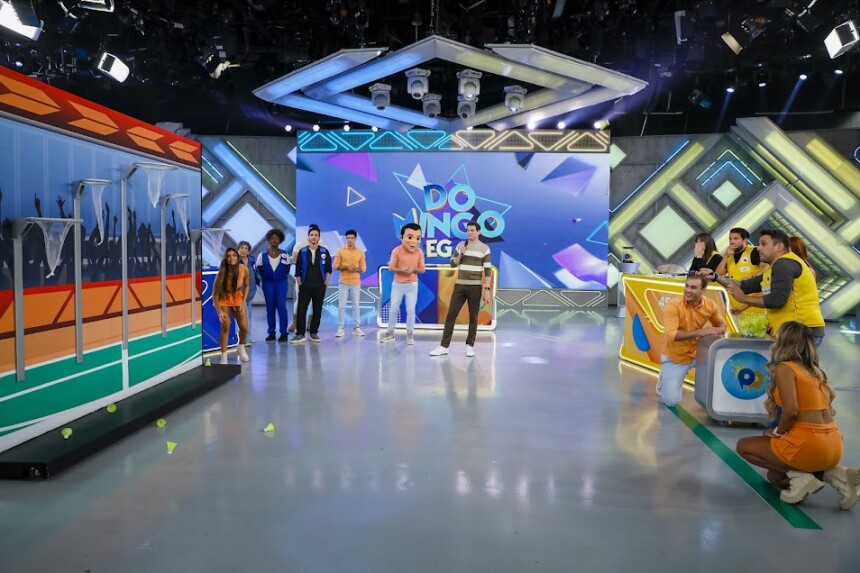Celso Portiolli no centro do palco organizando convidados para uma prova do Passa ou Repassa do Domingo Legal