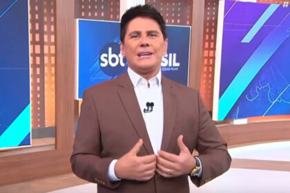 Cesar Filho, vestindo um terno marrom, gesticulando no estúdio do SBT Brasil