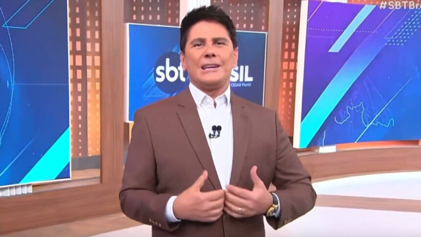 Cesar Filho, vestindo um terno marrom, gesticulando no estúdio do SBT Brasil