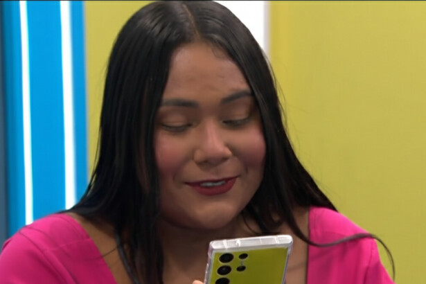 Chaiany com um celular na mão em trecho de dinâmica no BBB 26