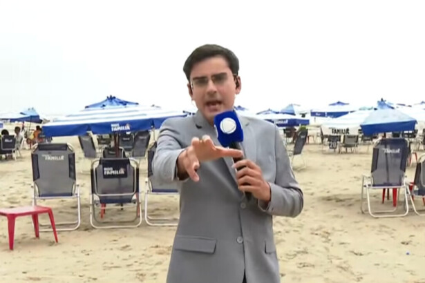 Dudu Camargo vestindo um terno cinza e microfone da RECORD na mão, em trecho de participação ao vivo no Balanço Geral