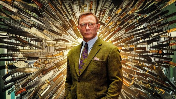 Daniel Craig de terno em frente a facas no poster do filme Entre Facas e Segredos