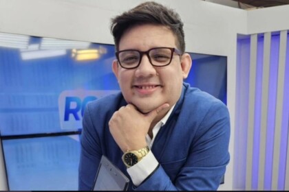 Erlan Bastos com a mão no rosto e sorridente