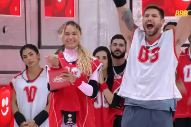 Jonas celebra vitória na Prova do Anjo e levanta os braços gritando ao lado de Sarah no BBB 26