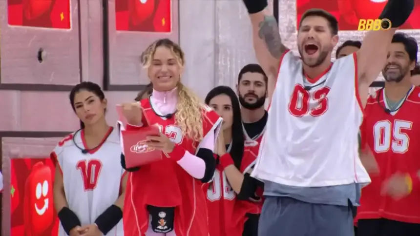 Jonas celebra vitória na Prova do Anjo e levanta os braços gritando ao lado de Sarah no BBB 26
